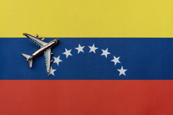 The plane over the flag of Venezuela, the concept of travel. Toy plane on the flag as a background.