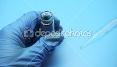 Doktor mavi bir sıvıyı laboratuvar pipet çevirir. Kimyasal araştırma laboratuvarı.