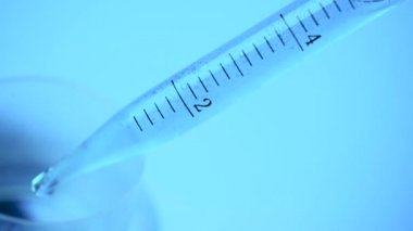 Laboratuvarda bir bilim adamı bir pipet ile tüp bebek mavi renk renkli bir sıvı analiz eder. Araştırma kavramı Biyokimya doğa, ilaç tıp