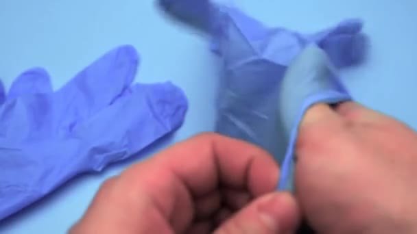 Der Arzt Trägt Vor Der Operation Latexhandschuhe Auf Blauem Hintergrund — Stockvideo