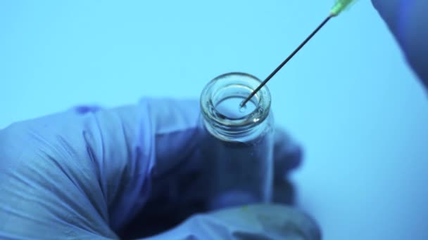 医師は 注射器から青い液体をフラスコに注ぐ 実験室で化学要素の研究 — ストック動画
