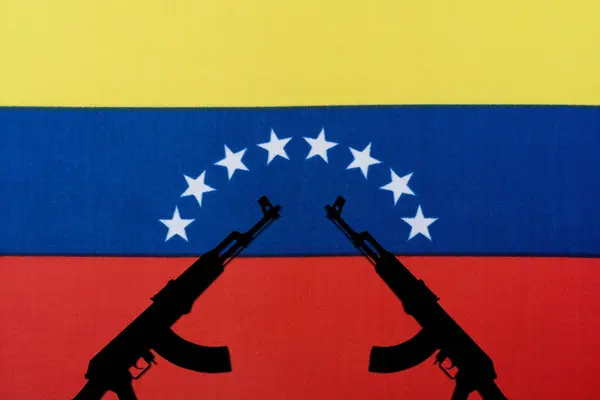 Várias espingardas automáticas levantadas no fundo da bandeira venezuelana — Fotografia de Stock