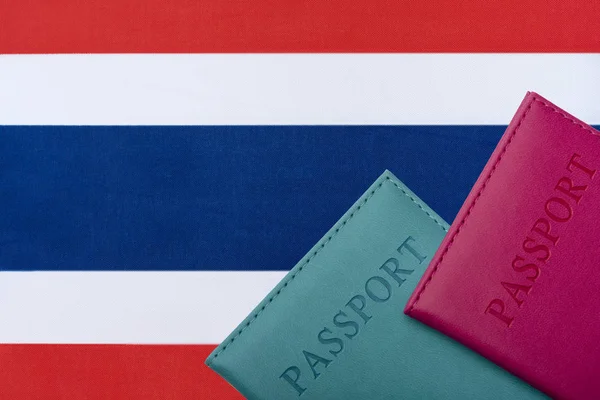 Sullo sfondo della bandiera della Thailandia si trova un passaporto . — Foto Stock