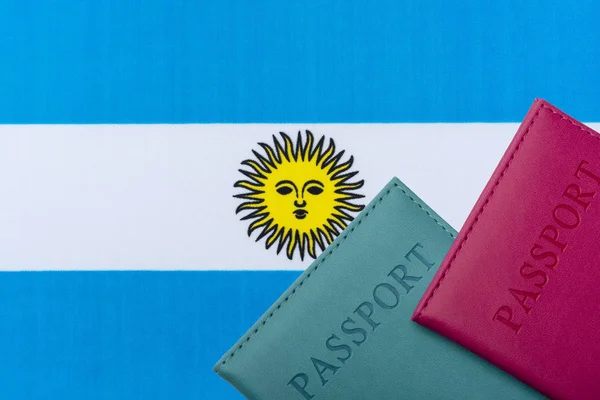 Na pozadí argentinské vlajky leží cestovní pas. — Stock fotografie
