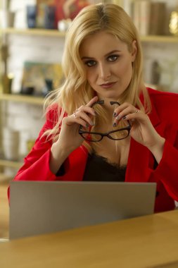 Güzel sarışın iş kadını evde bir dizüstü bilgisayarüzerinde çalışıyor.