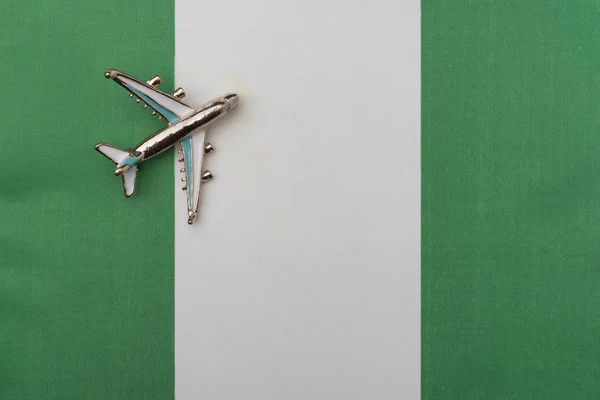 Avión sobre la bandera de Nigeria concepto de viaje . — Foto de Stock