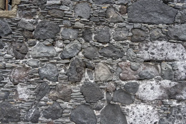 The stone texture of the wall or track.