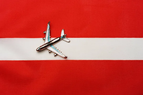 Avión sobre la bandera de Austria el concepto de viajes y turismo . — Foto de Stock