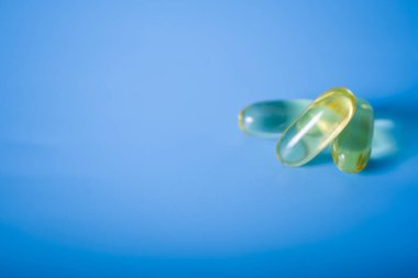 Mavi arka planda Omega 3 sağlık kapsülleri. Sağlıklı yaşam kavramı.