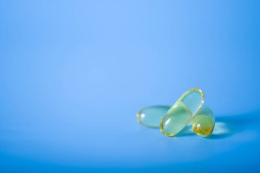 Mavi arka planda Omega 3 sağlık kapsülleri. Sağlıklı yaşam kavramı.