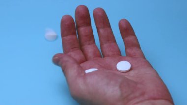 Haplar mavi arka planda eline düşer. İlaç ve bağımlılık kavramı.