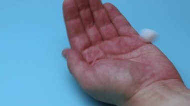 Haplar mavi arka planda eline düşer. İlaç ve bağımlılık kavramı.