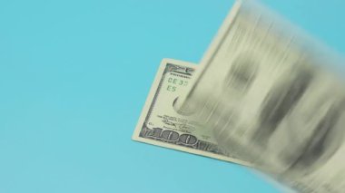 Masaya maviler içinde yüz dolarlık banknotlar konur. Zenginlik ve refah kavramı.