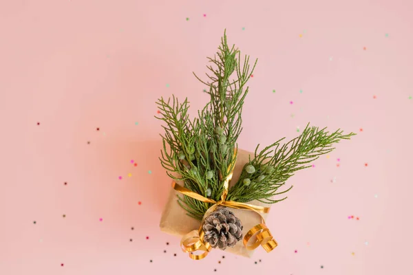 クリスマスプレゼントInクラフト紙Withモミの枝とロリポップオンピンクの背景に多色キャンディで場所とテキスト番号2021クリスマスコンセプト — ストック写真
