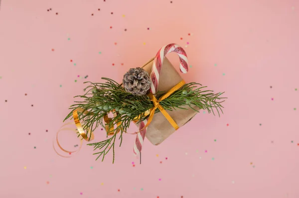 Prezent Świąteczny Papier Kraft Gałązką Jodły Lizakiem Różowym Tle Wielobarwnych — Zdjęcie stockowe