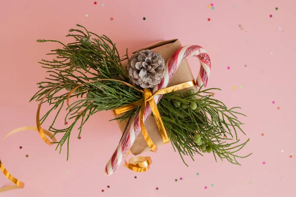 用杉木枝条做的牛皮纸和粉色背景的棒棒糖做的圣诞礼物 用彩色糖果配上数字2021的圣诞礼物 — 图库照片