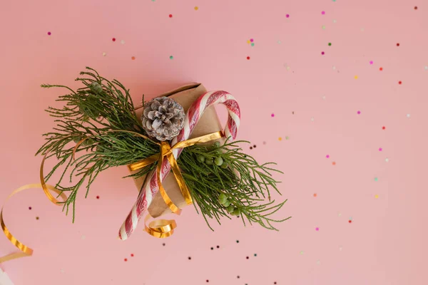 クリスマスギフトでクラフト紙とともにモミの枝とロリポップ上の灰色の背景にマルチカラーキャンディで場所とテキストクリスマスのコンセプト — ストック写真