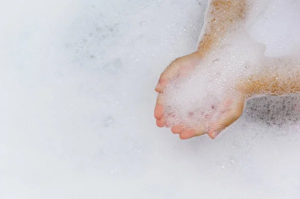 Child Plays Bathtub Filled White Foam Palms Hold Foam Bathing — Stock Photo, Image