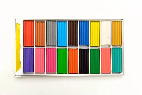 Mehrfarbige Knetmasse in einer Schachtel, 18 Farben, auf weißem Hintergrund, von oben aufgenommen — Stockfoto