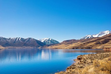 Berrak bir kış gününde çöl manzarasında Deer Creek Rezervuarı Heber Vadisi, Utah 'ta huzur ve sükunet içinde oturur.. 
