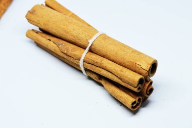 Beyaz arka planda gölgesi olmayan mis kokulu tarçın çubukları.