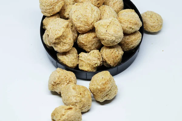 Vejetaryen ve vejetaryen yiyeceklerde kullanılan soya proteini parçaları, beyaz arka planda izole edilmiş.