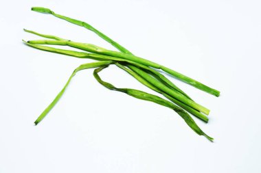 İzole edilmiş beyaz arka planda kökleri olan taze yeşil bahar soğanı.