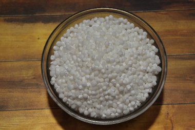 Beyaz sago incileri ya da sabudana çiğ sago topları ahşap kasede izole edilmiş.