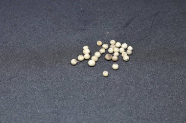 Siyah arkaplanda beyaz biber tohumları izole