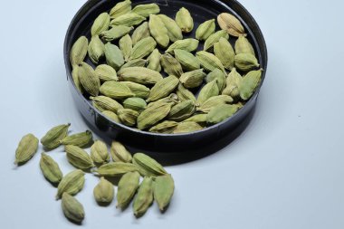 Beyaz arka planda izole edilmiş yeşil kakule tohumları.