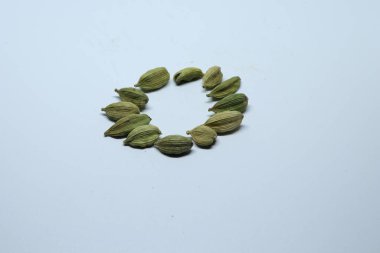 Beyaz arka planda izole edilmiş yeşil kakule tohumları.