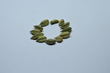 Beyaz arka planda izole edilmiş yeşil kakule tohumları.