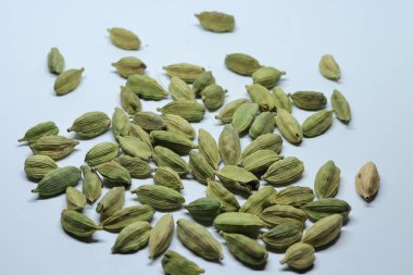 Beyaz arka planda izole edilmiş yeşil kakule tohumları.