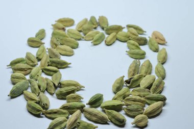 Beyaz arka planda izole edilmiş yeşil kakule tohumları.