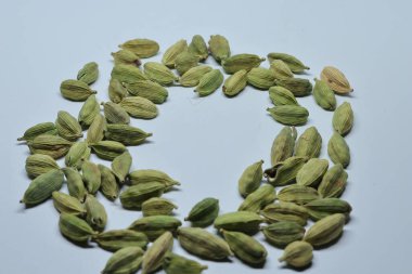 Beyaz arka planda izole edilmiş yeşil kakule tohumları.