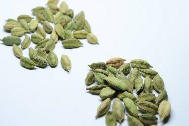 Beyaz arka planda izole edilmiş yeşil kakule tohumları.