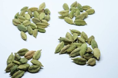 Beyaz arka planda izole edilmiş yeşil kakule tohumları.