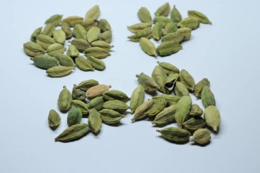 Beyaz arka planda izole edilmiş yeşil kakule tohumları.