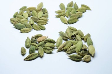 Beyaz arka planda izole edilmiş yeşil kakule tohumları.