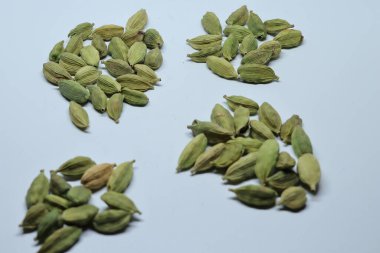 Beyaz arka planda izole edilmiş yeşil kakule tohumları.