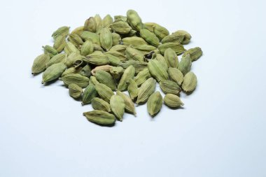 Beyaz arka planda izole edilmiş yeşil kakule tohumları.