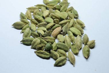 Beyaz arka planda izole edilmiş yeşil kakule tohumları.