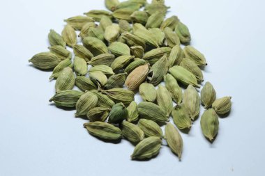 Beyaz arka planda izole edilmiş yeşil kakule tohumları.