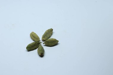 Beyaz arka planda izole edilmiş yeşil kakule tohumları.