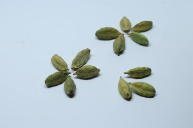 Beyaz arka planda izole edilmiş yeşil kakule tohumları.
