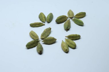 Beyaz arka planda izole edilmiş yeşil kakule tohumları.