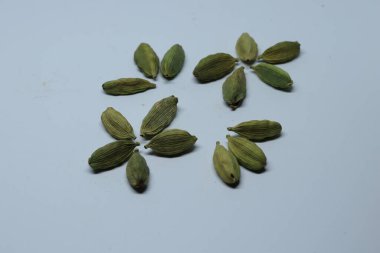 Beyaz arka planda izole edilmiş yeşil kakule tohumları.