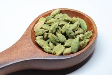 Beyaz arka planda izole edilmiş yeşil kakule tohumları.