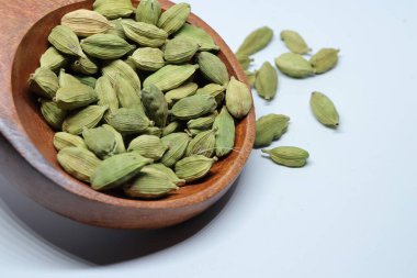 Beyaz arka planda izole edilmiş yeşil kakule tohumları.