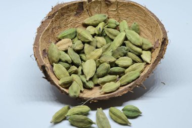 Beyaz arkaplanda izole edilmiş küçük yeşil kardamon tohumu yığını